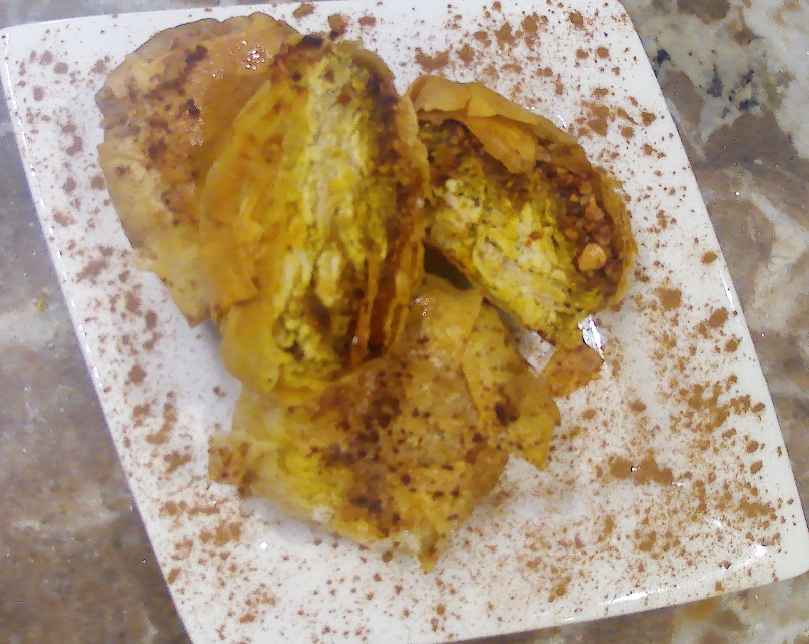 Pastilla au poulet dorée et croustillante, garnie de poulet fondant, sauce aux œufs et amandes grillées.