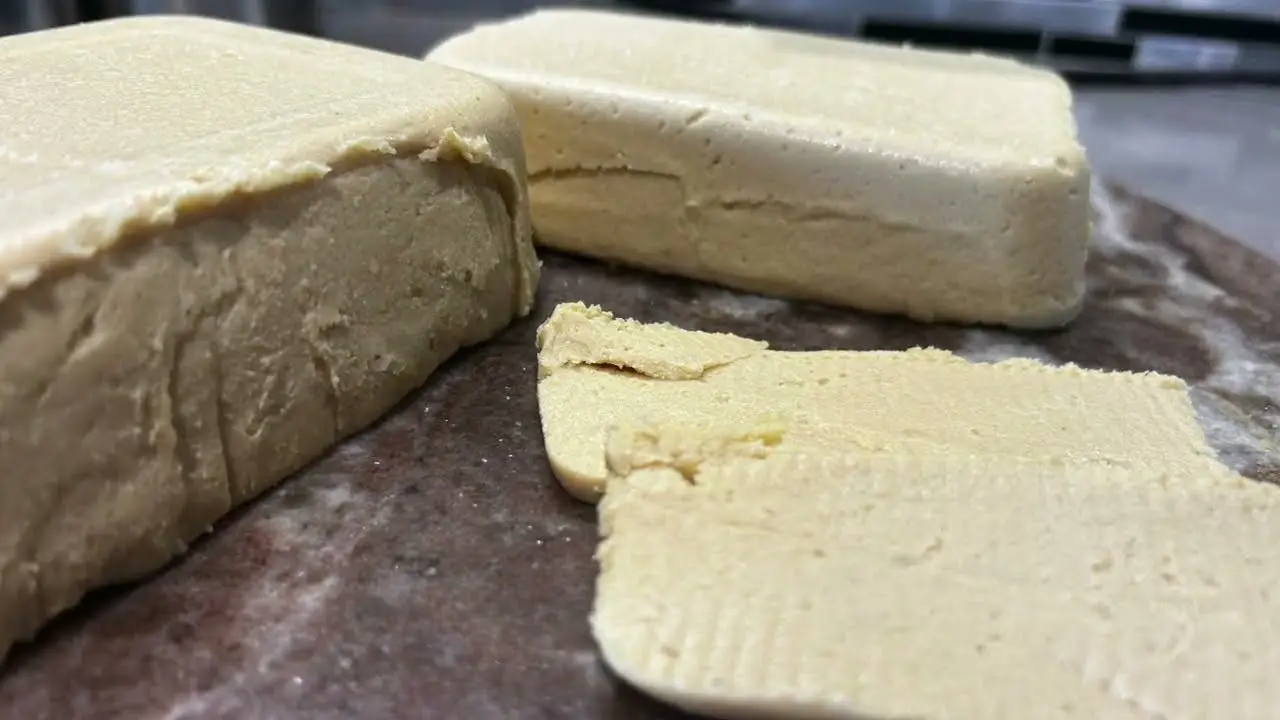 Fromage de cajou végétal crémeux moulé dans un petit récipient, avec une texture lisse et ferme, prêt à être servi.