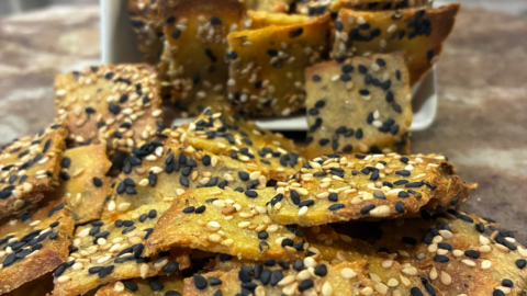 Craquelins de quinoa trempé, dorés et croustillants, étalés sur une plaque.