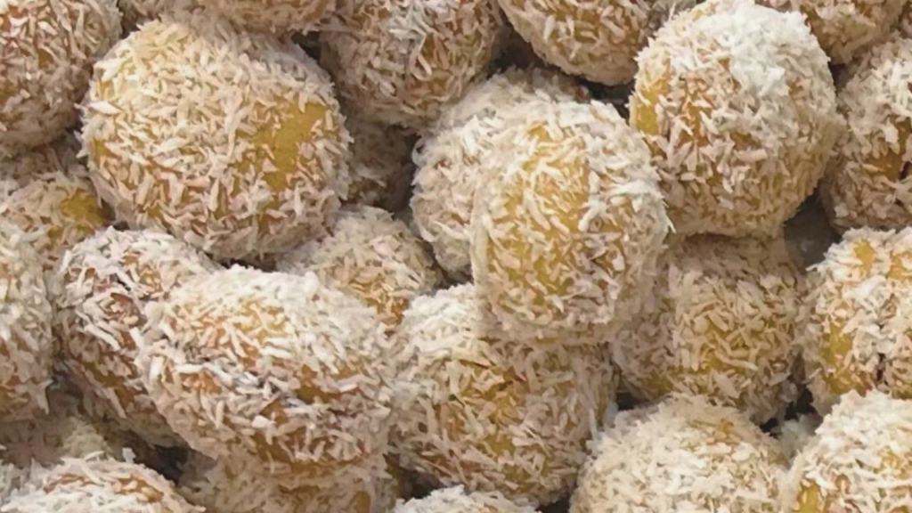Boules de coco légères et fondantes, collées deux par deux avec du miel et roulées dans de la noix de coco râpée