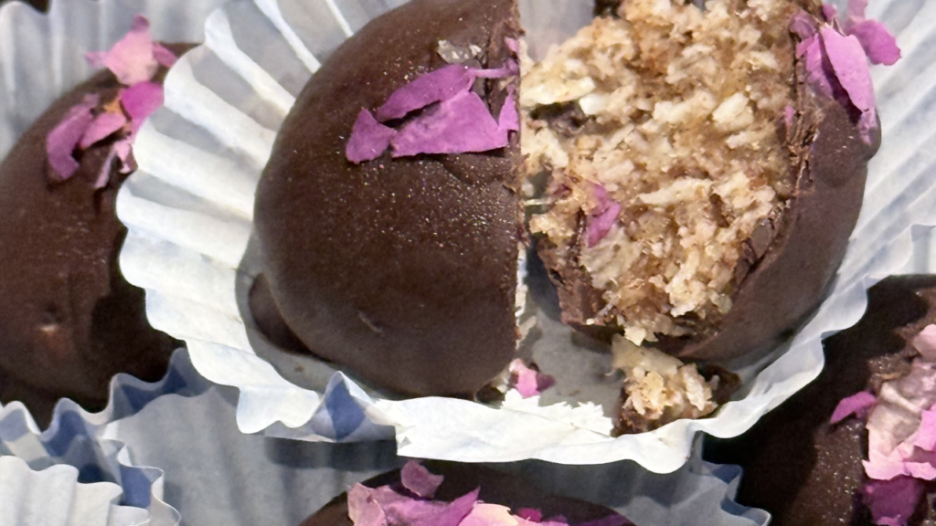 Boules de coco keto sans sucre, enrobées de chocolat noir et décorées de pétales de roses